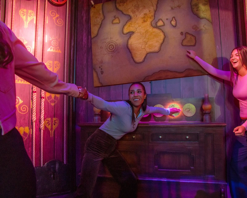 Three girls hold hands to solve a puzzle and escape their room.