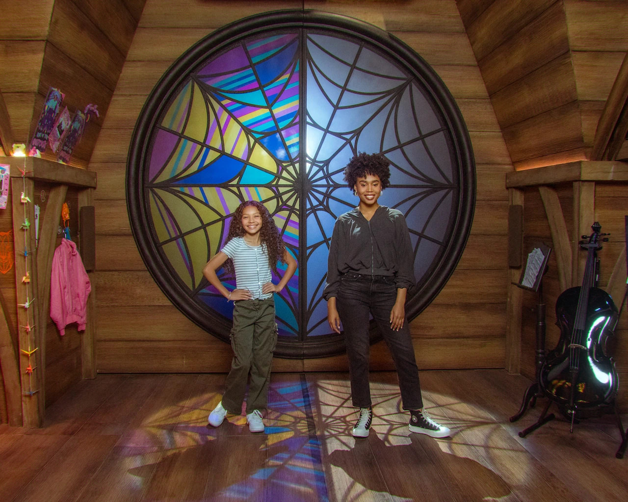 Two friends pose in Enid and Wednesday's dorm room at the Wednesday immersive experience.