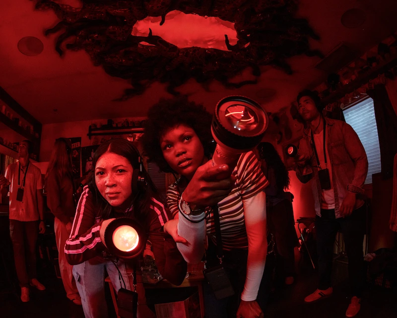 Two friends use flashlights to find clues in the immersive Stranger Things experience.