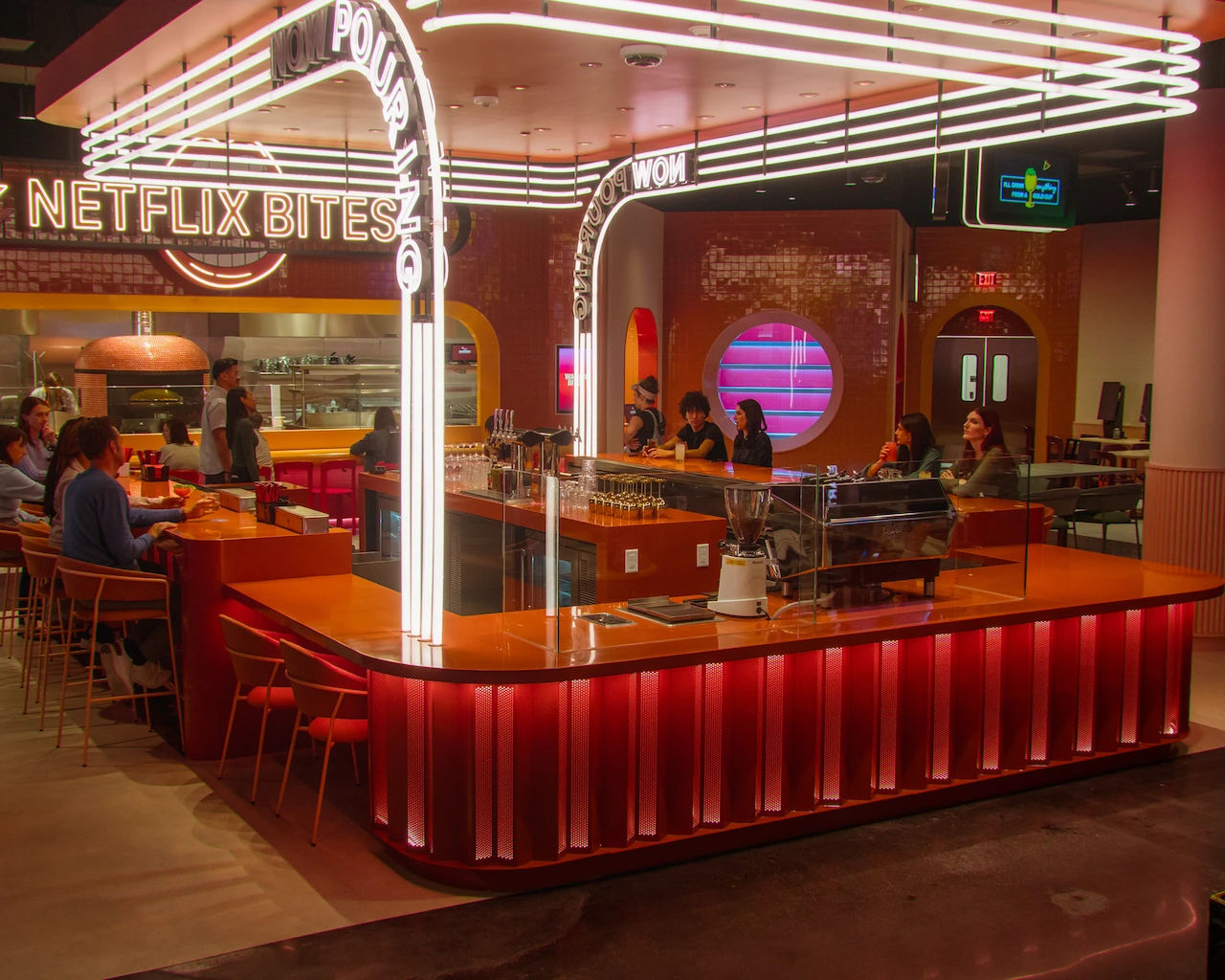 Several guests sit at the full bar area of Netflix Bites. 