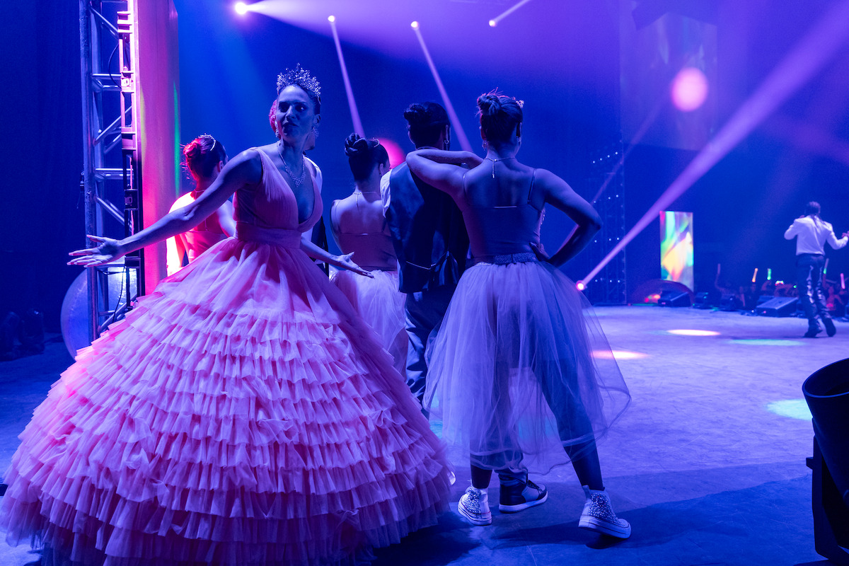 Genesis Rodriguez as Isa stands backstage wearing a gown in Season 1 of ‘Neon.’