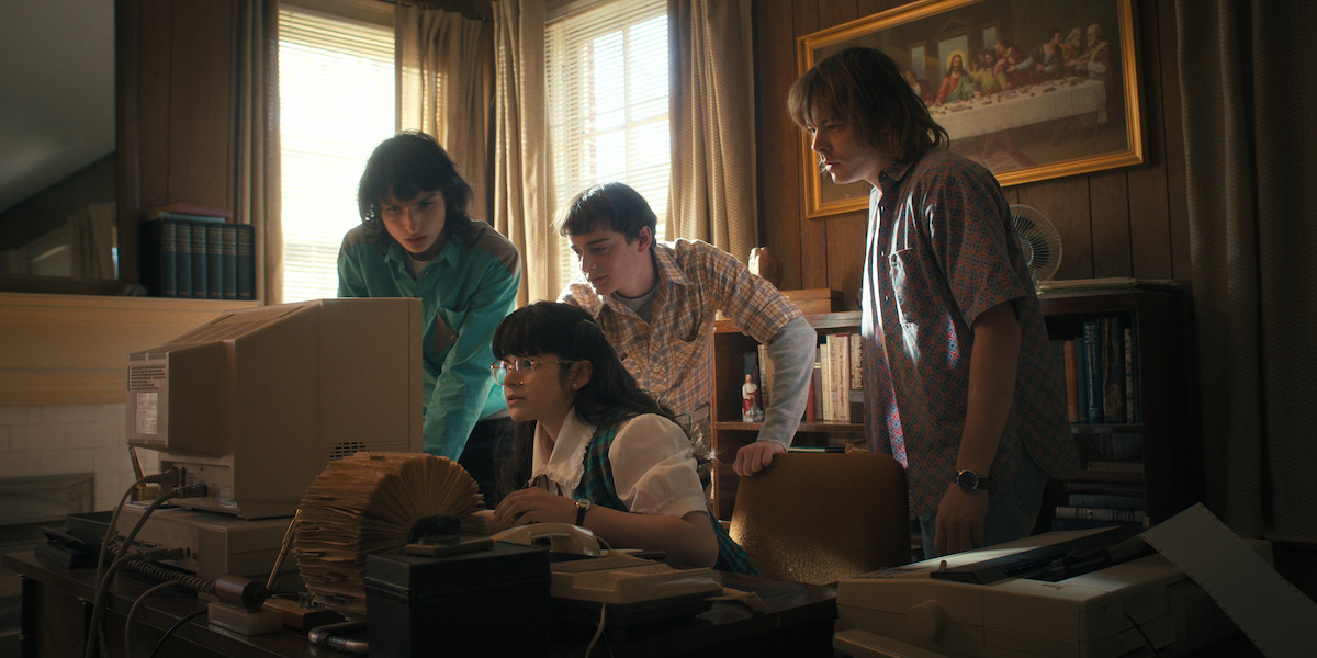 Finn Wolfhard as Mike Wheeler, Gabriella Pizzolo as Suzie, Noah Schnapp as Will Byers, and Charlie Heaton as Jonathan Byers in ‘Stranger Things’ Season 4.