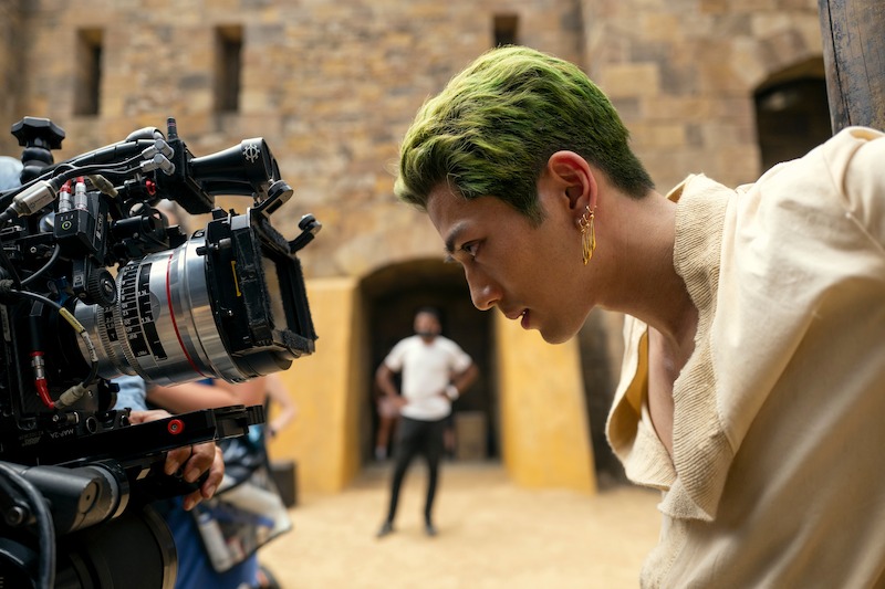 Mackenyu as Roronoa Zoro looks into a camera filming him in Season 1 of 'One Piece.'