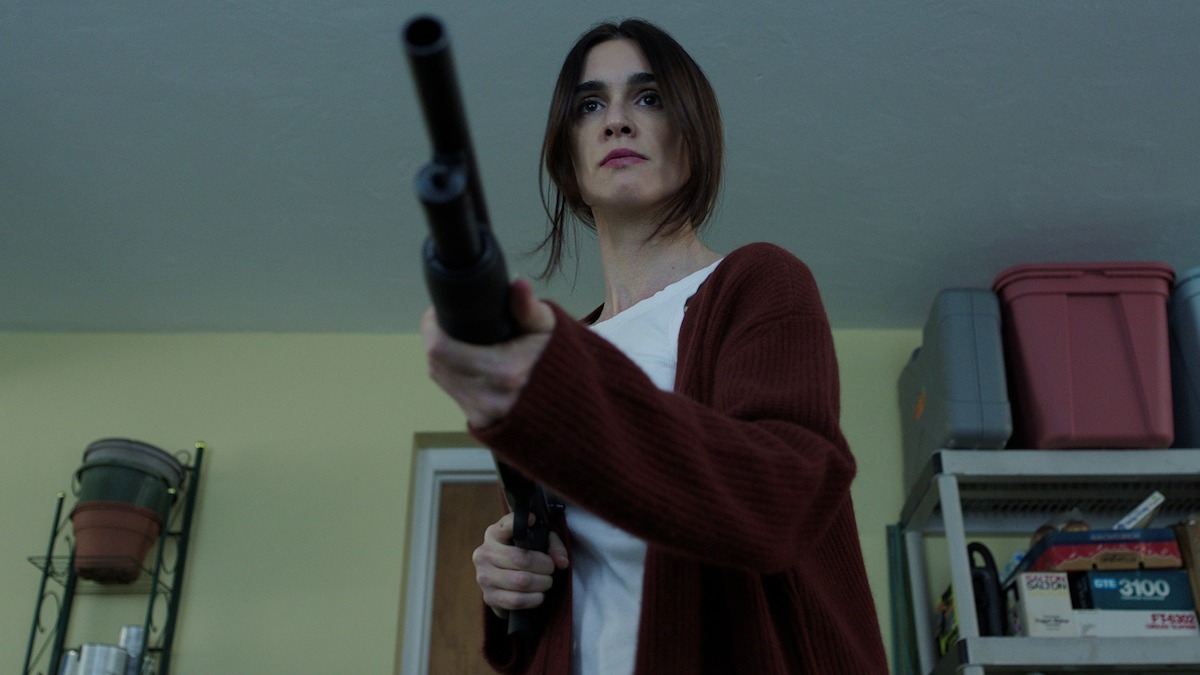 A character holding a shotgun on someone off screen.