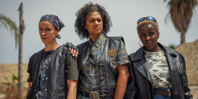 Three women wear leather jackets and show tough expressions in Season 1 of 'Kaos'