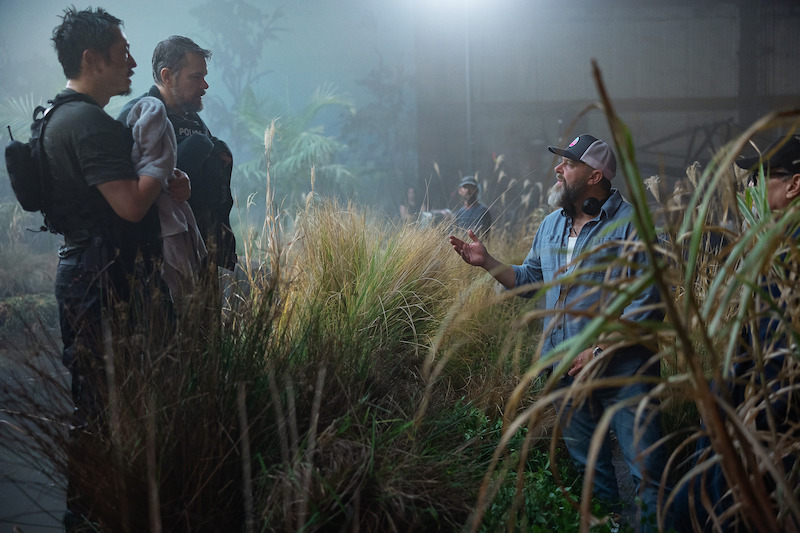 Steven Yeun as Detective Mike Ro, Matt Damon as Lieutenant Dane Dumars, and writer and director Joe Carnahan on the set of 'The Rip.'