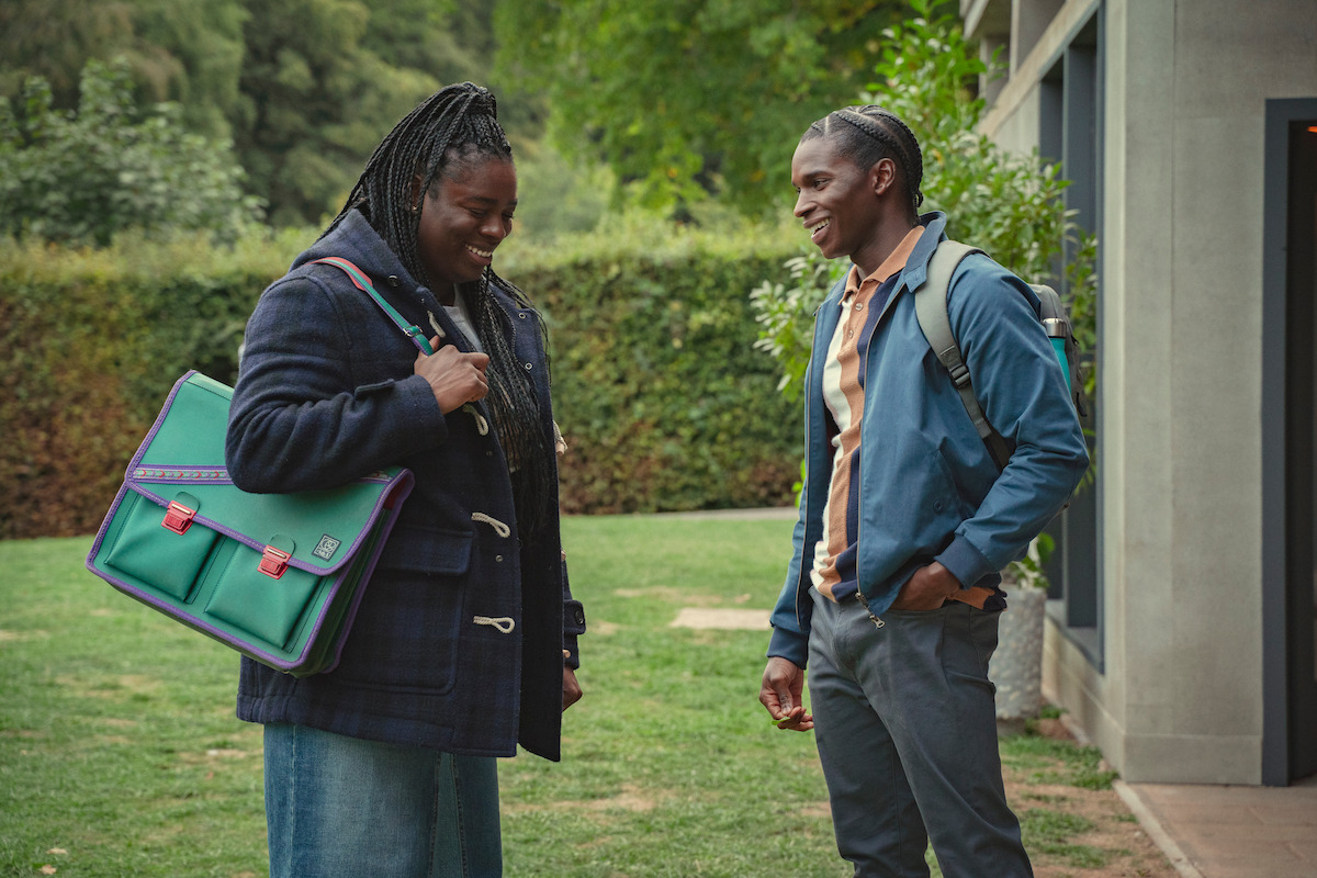 Chinenye Ezeudu as Viv and Kedar Williams-Stirling as Jackson smile together outside of school in Season 4 of ‘Sex Education.’ 