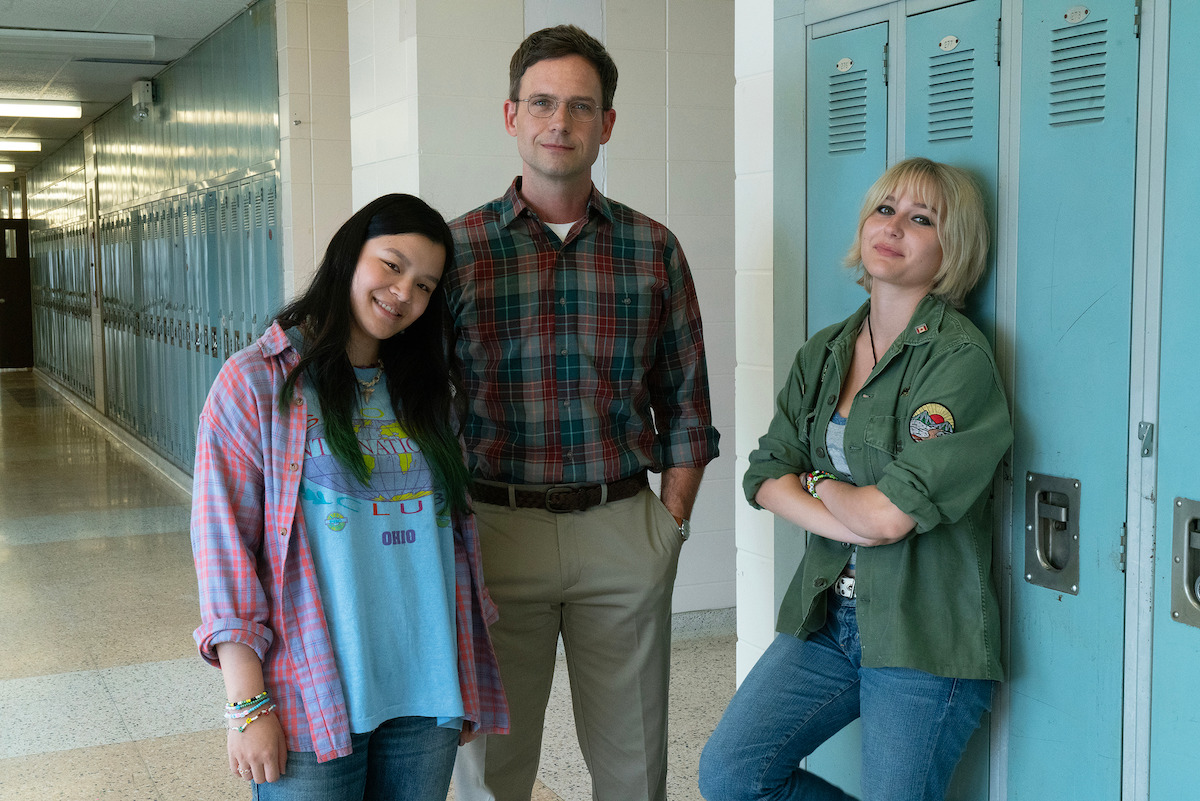 Behind-the-scenes image of Sydney Topliffe, Patrick J. Adams, and Alyvia Alyn Lind standing in a high school hallway together in Season 1 of ‘Wayward’