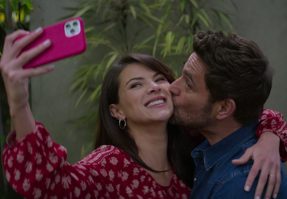 Couple kissing and holding a camera