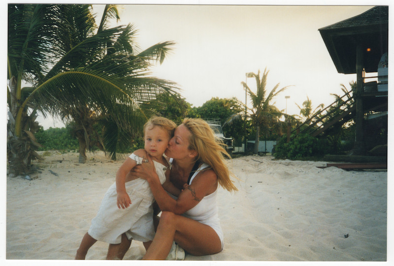Pamela sharing a kiss with her son on the beach.