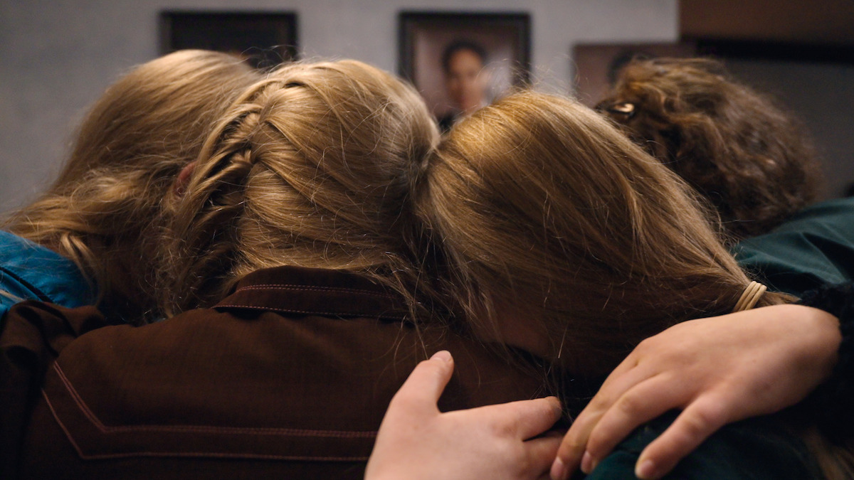 Women from Sam’s sect hug each other