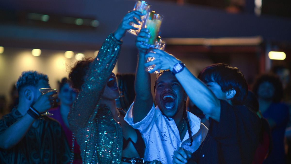 Emma Ferreira as Ness, Tyler Dean Flores as Santi, and Jordan Mendoza as Felix raise their glasses in celebration at a club in Season 1 of ‘Neon.’