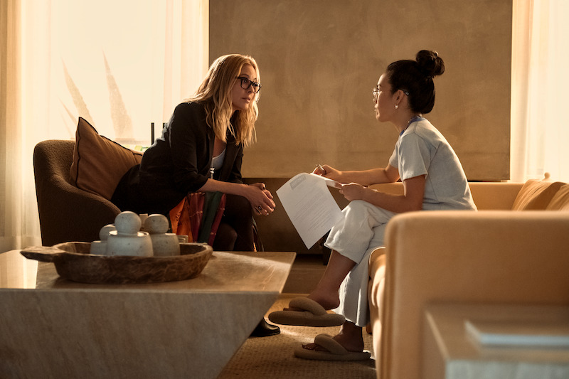 two women sitting on couches opposite each other