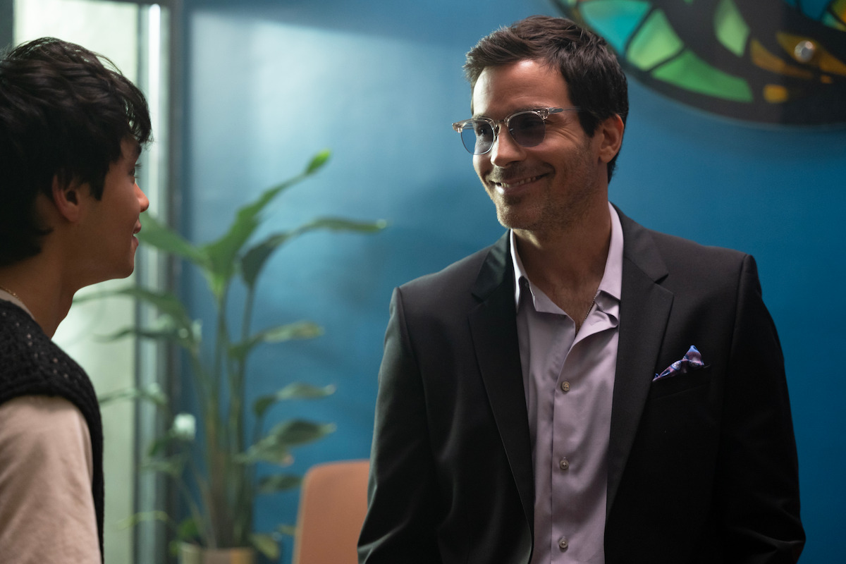 Santiago Cabrera as Oscar stands in his office smiling in Season 1 of ‘Neon.’
