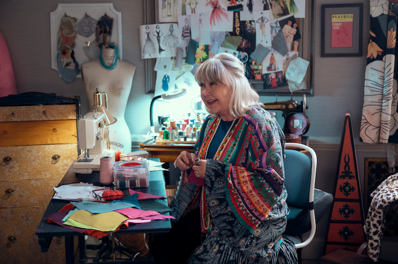 Susan Ruttan as Gladys sits at a table with a sewing machine in Season 1 of 'A Man on the Inside'