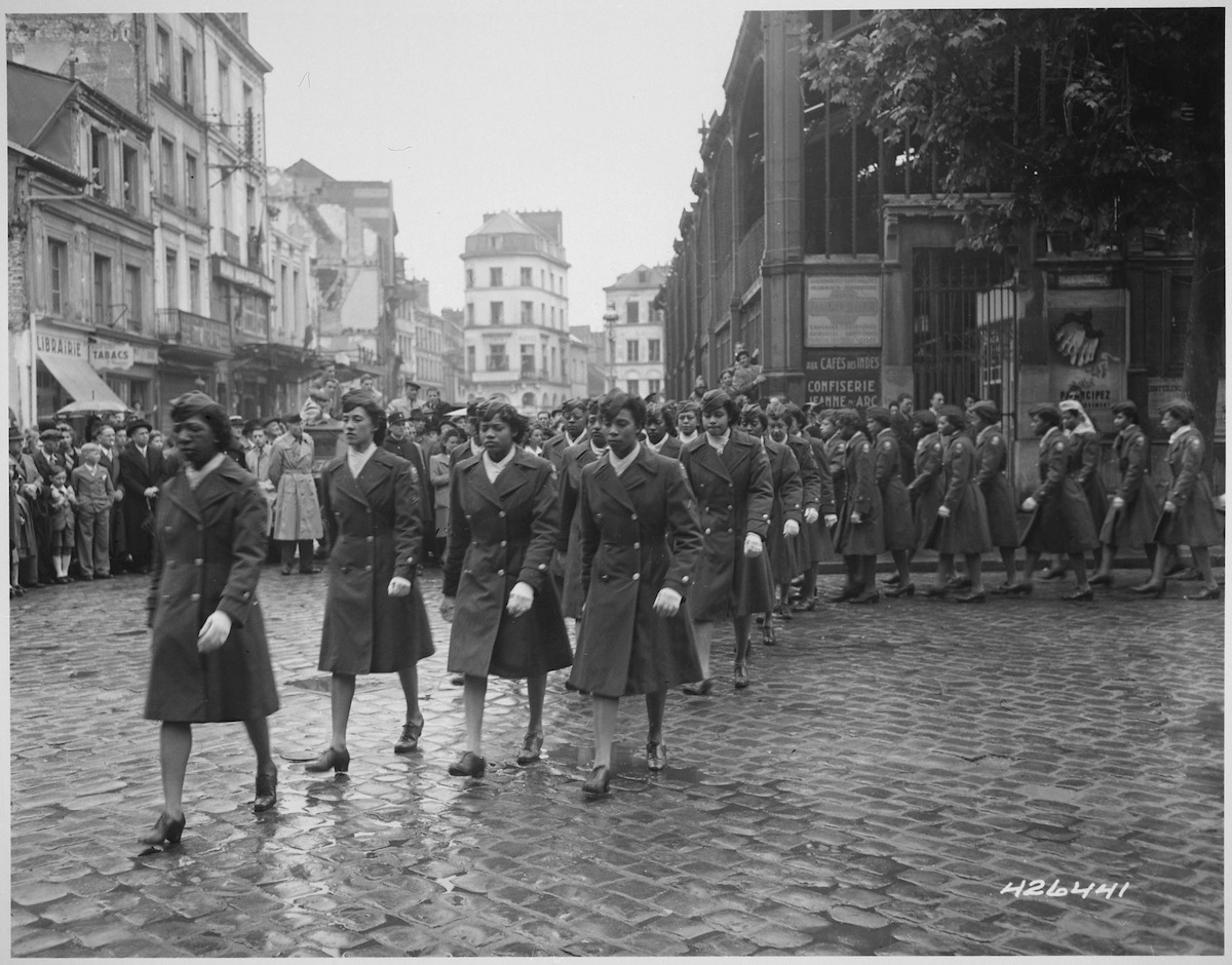 Members of the 6888th Central Postal Directory Battalion take part in a parade ceremony in honor of Joan d'Arc at the marketplace where she was burned at the stake, 1945. Image courtesy National Archives.