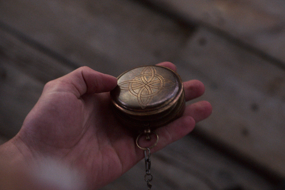 Chase Stokes as John B in Outer Banks holds compass.