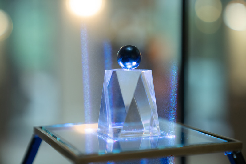 A small blue ball rests on a glass pedestal in Season 3 of 'Lupin.'