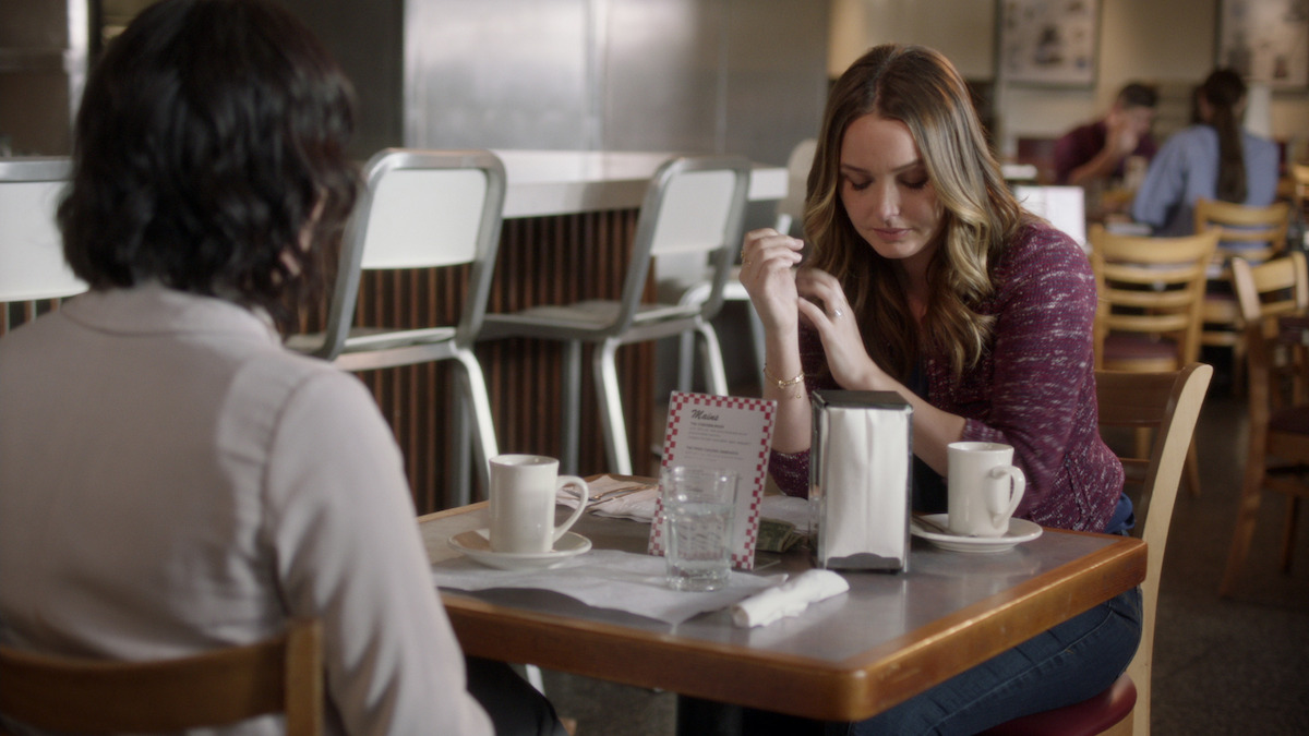 two women sitting across from each other in a diner. 