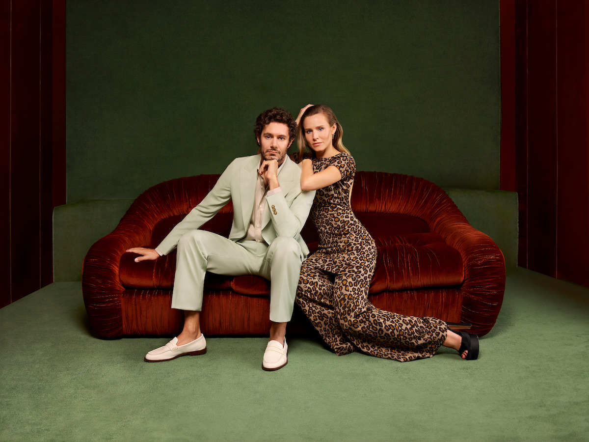 Noah (Adam Brody) and Joanne (Kristen Bell) sit on a red velvet couch in a green room.