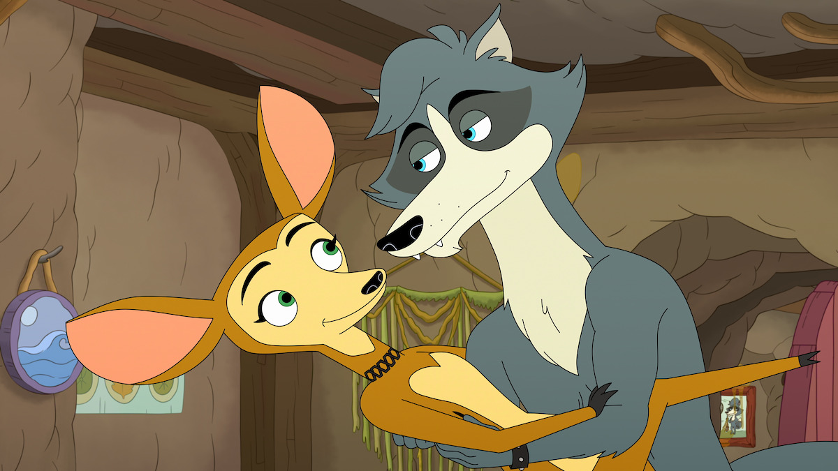 Animated wolf and deer characters sharing a close moment inside a cozy, earth-toned, cave-like home with wooden accents and a small painting on the wall in the background.