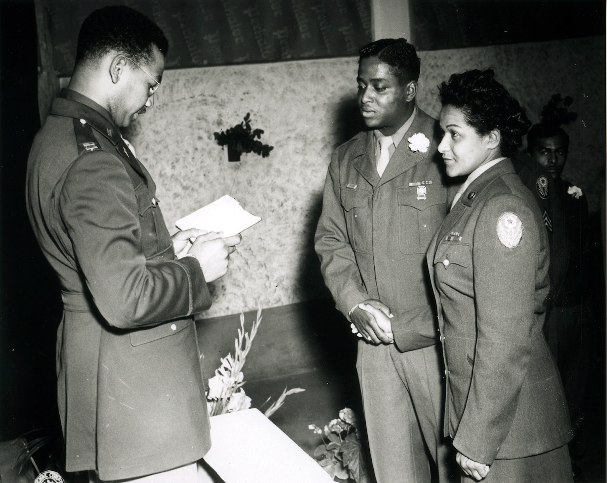 Chaplain William J. Green reads the benediction at the marriage ceremony of Private First Class Florence A. Collins, of the 6888th Postal Directory Battalion, to Corporal William A. Johnson of the 1696th Labor Supervision Company, in Rouen, France, August, 1945. This is the first African American marriage to be performed in the European Theater of Operations.
