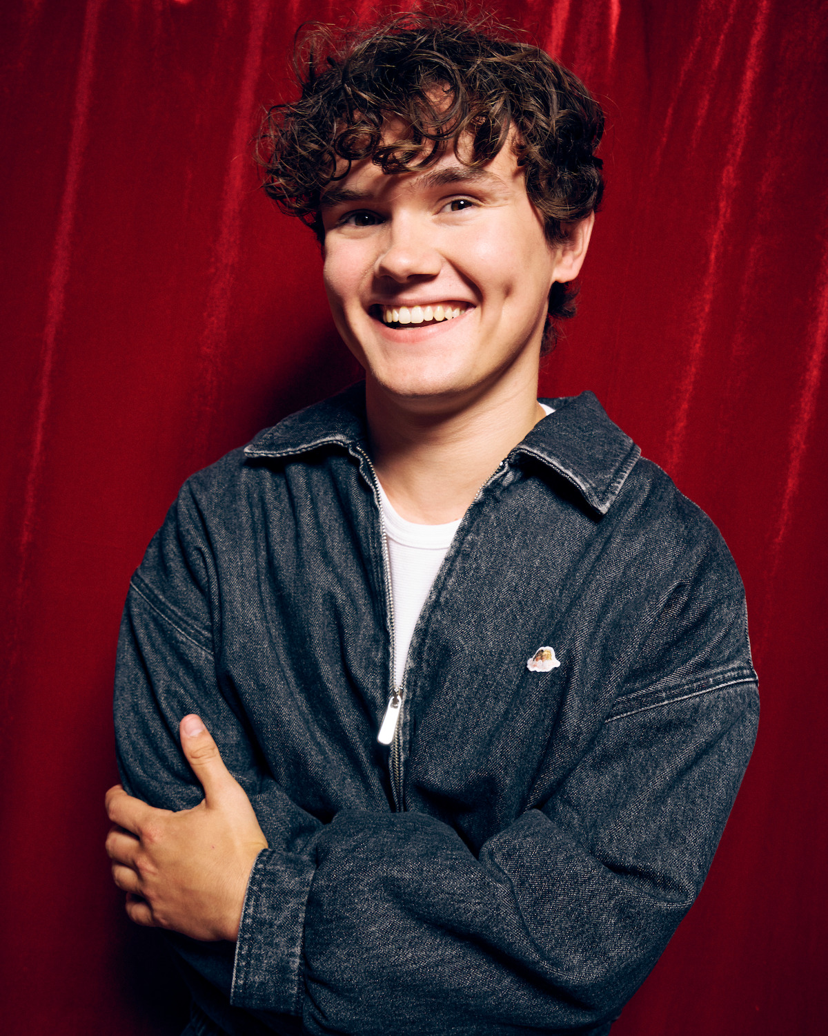Will Tilston against a red photo booth backdrop