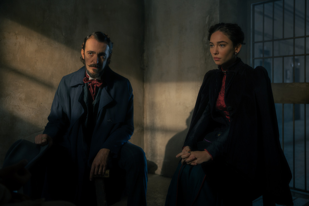 Lidia Poet sitting with a man in a cell