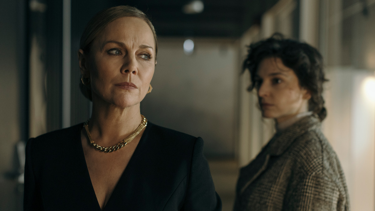In an image from the series ‘Just One Look,’ a woman looks off to the side as Maria Dębska stands behind her, out of focus.
