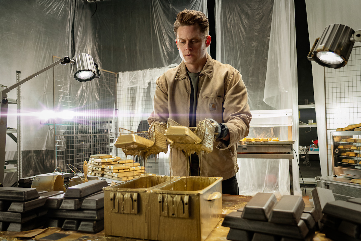 Billy Magnussen as Magnus holding gold bars in ‘Lift’