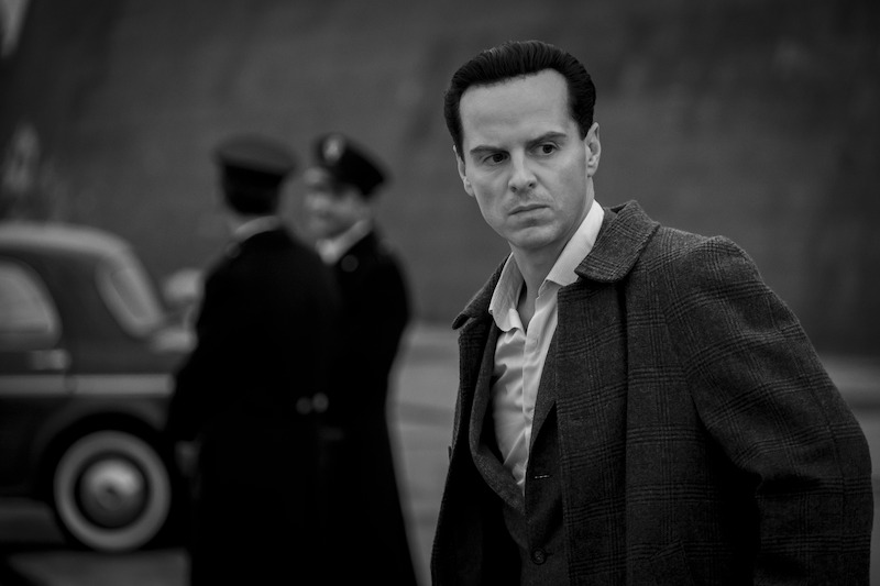 Andrew Scott as Tom Ripley walks by two police officers in 'Ripley'