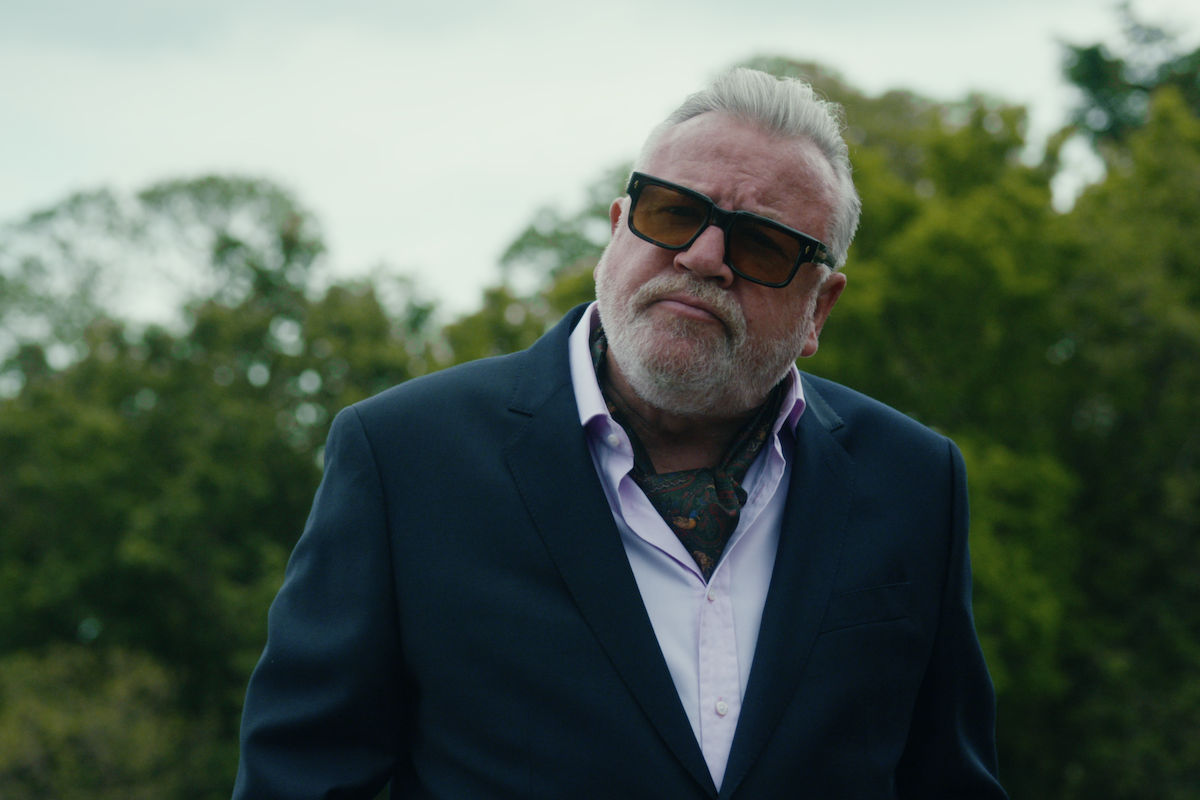 Ray Winstone as Bobby Glass wears a blue jacket and sunglasses in Season 1 of ‘The Gentlemen’