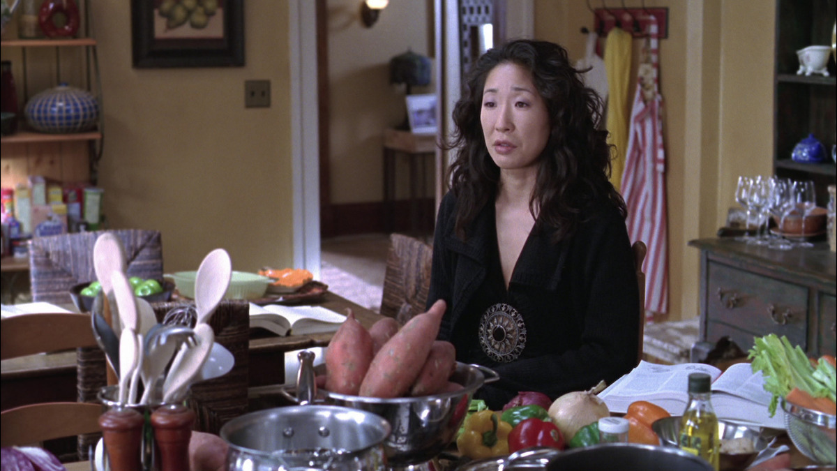 Sandra Oh in the kitchen, looking defeated by all the cooking she has to do. 