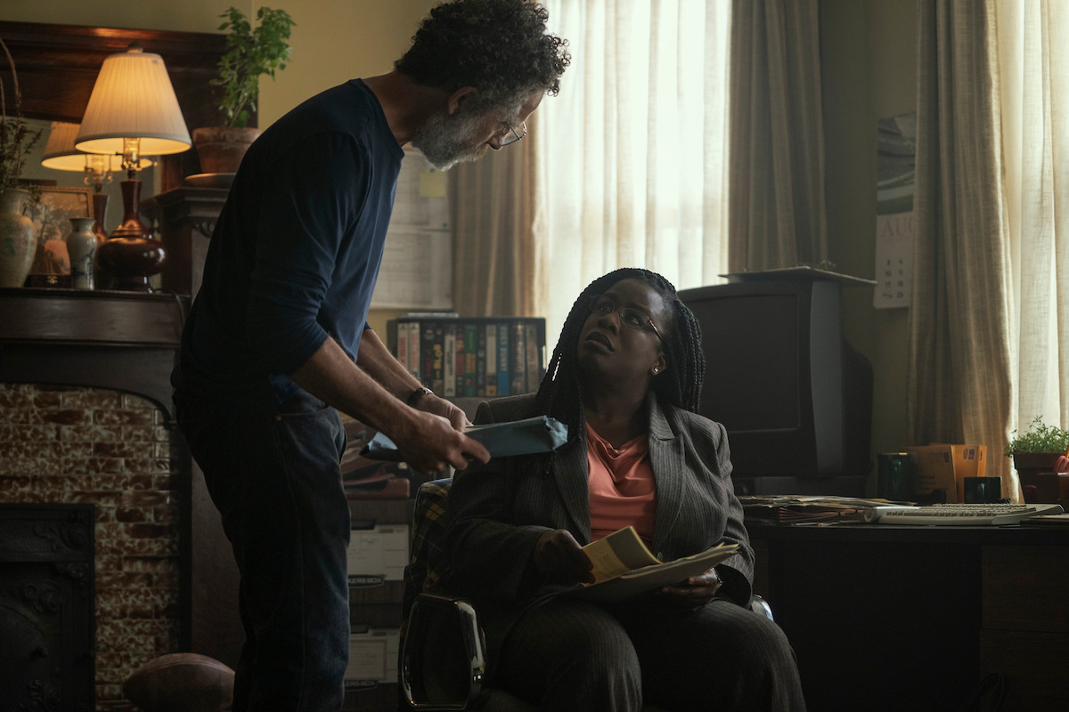 John Ales as Dr. Gregory Fitzgibbons and Uzo Aduba as Edie look through files together in Season 1 of ‘Painkiller.’