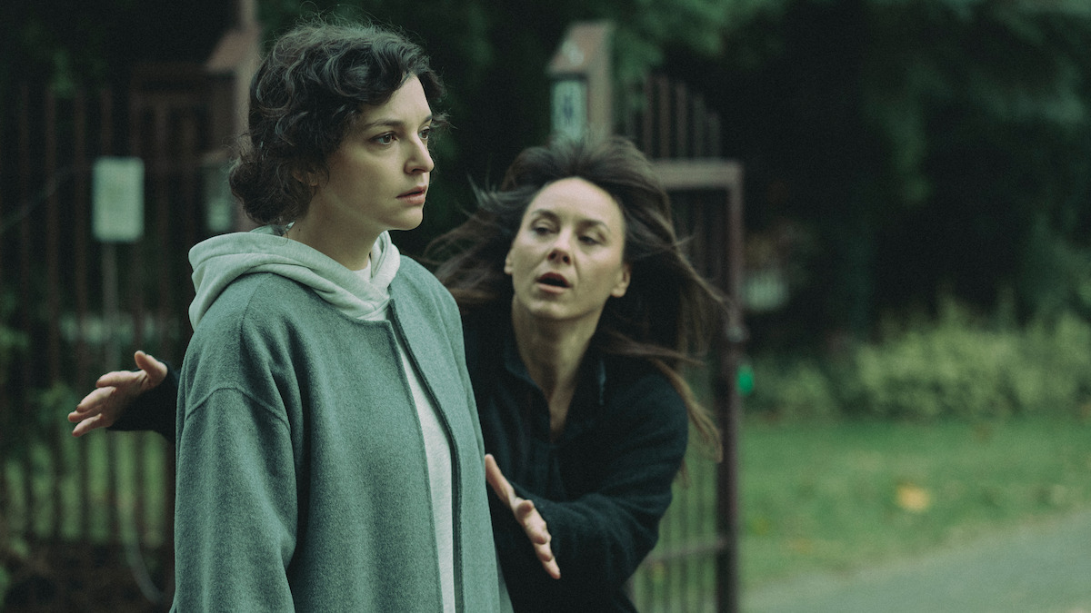 Maria Dębska stands while a woman runs toward her in the series ‘Just One Look.’