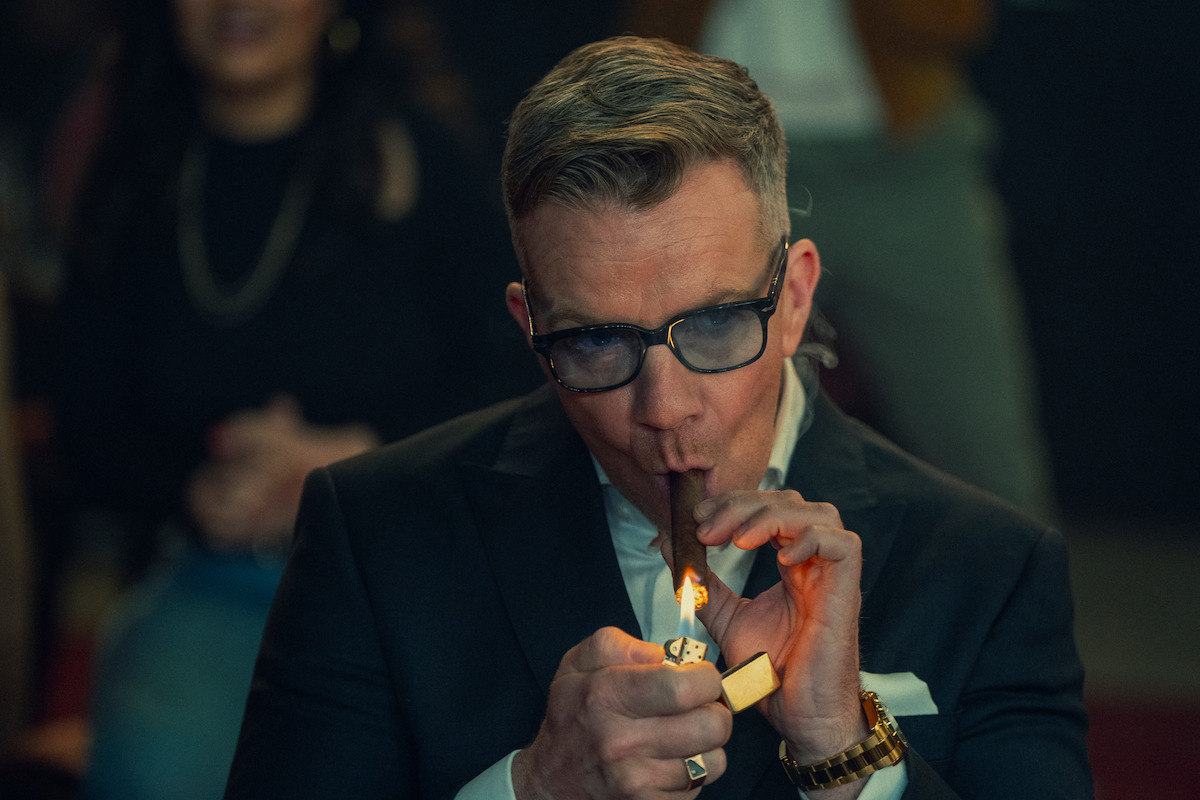 Max Beesley as Henry Collins lights a cigar in season 1 of ‘The Gentlemen’