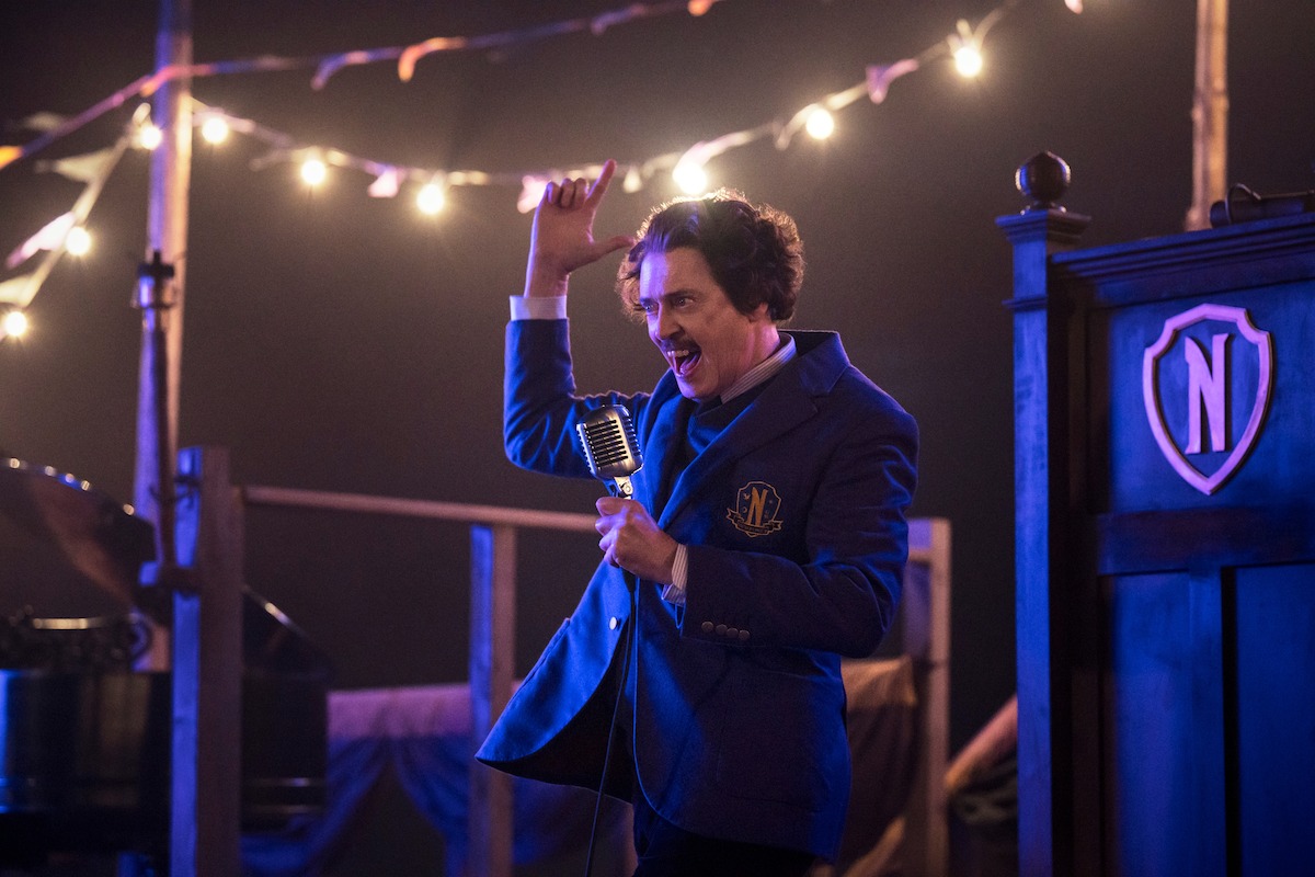 Steve Buscemi as Barry Dort speaks on a stage in Season 2 of ‘Wednesday’