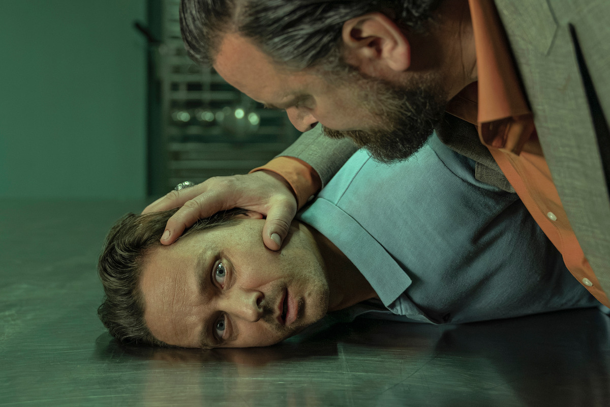 Sascha Geršak pushes Tom Schilling’s head onto a steel surface with his hand in an image from ‘Murder Mindfully’