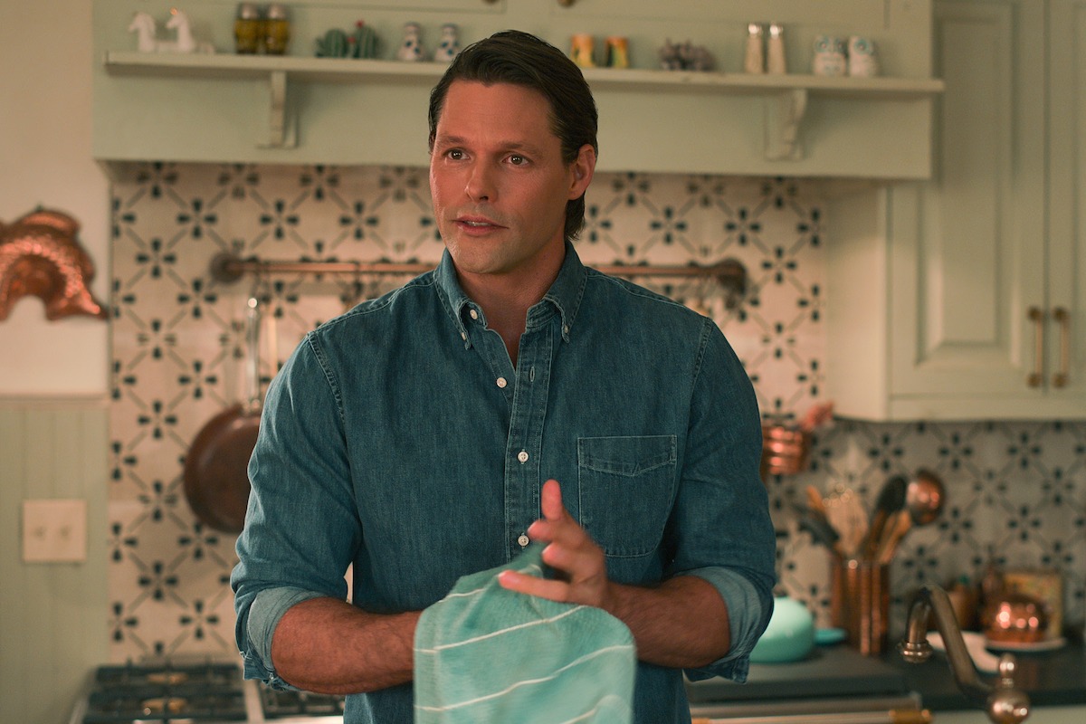 Justin Bruening as Cal holds a towel in a kitchen in Season 3 of ‘Sweet Magnolias.’