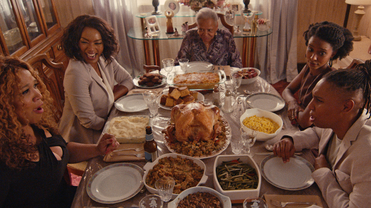 A family gathers around a table with a thanksgiving feast. 