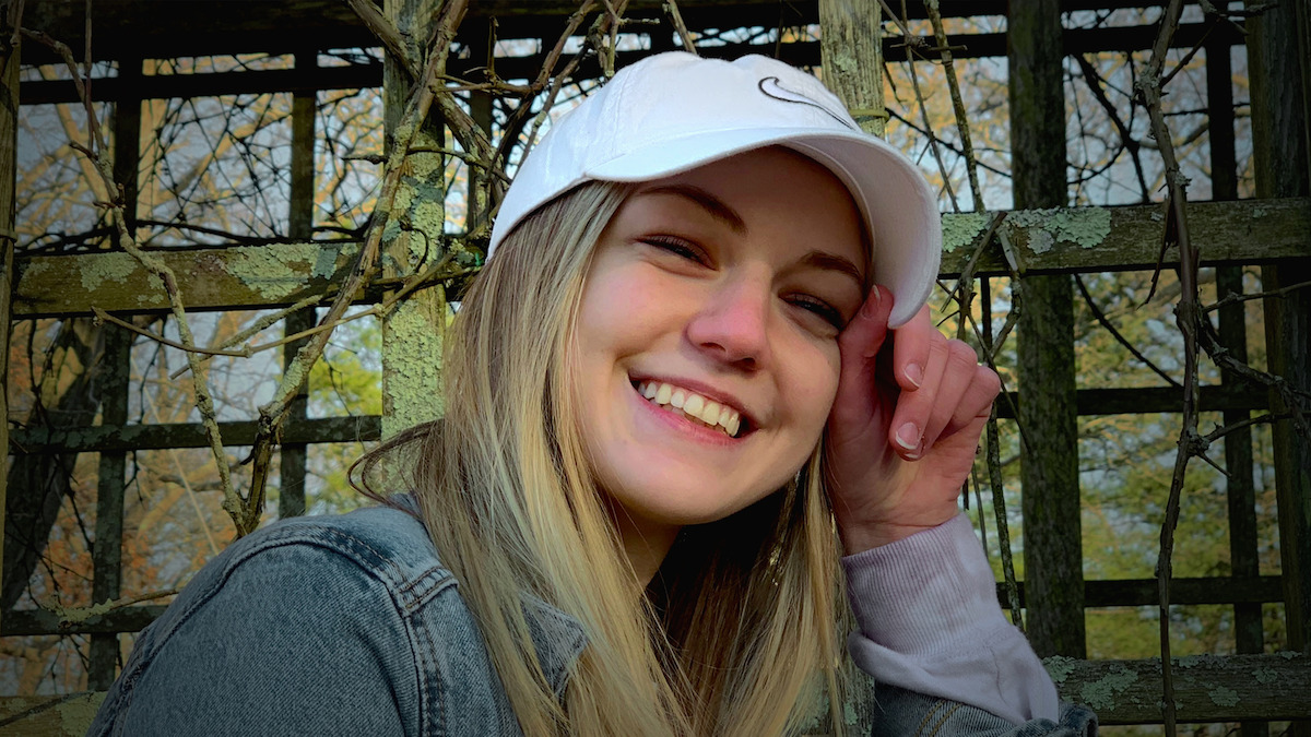 Gabby Petito smiling with a white cap on