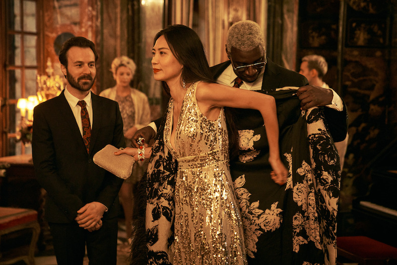 Antoine Gouy as Benjamin Ferel, Win Wang as Tara Xang, and Omar Sy as Assane Diop stand together as a party in Season 3 of 'Lupin.'