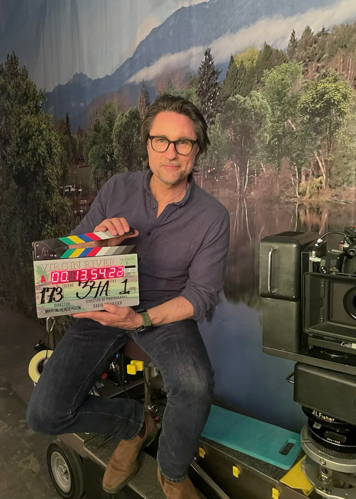 Martin Henderson behind the scenes on the ‘Virgin River’ set holding a clapboard