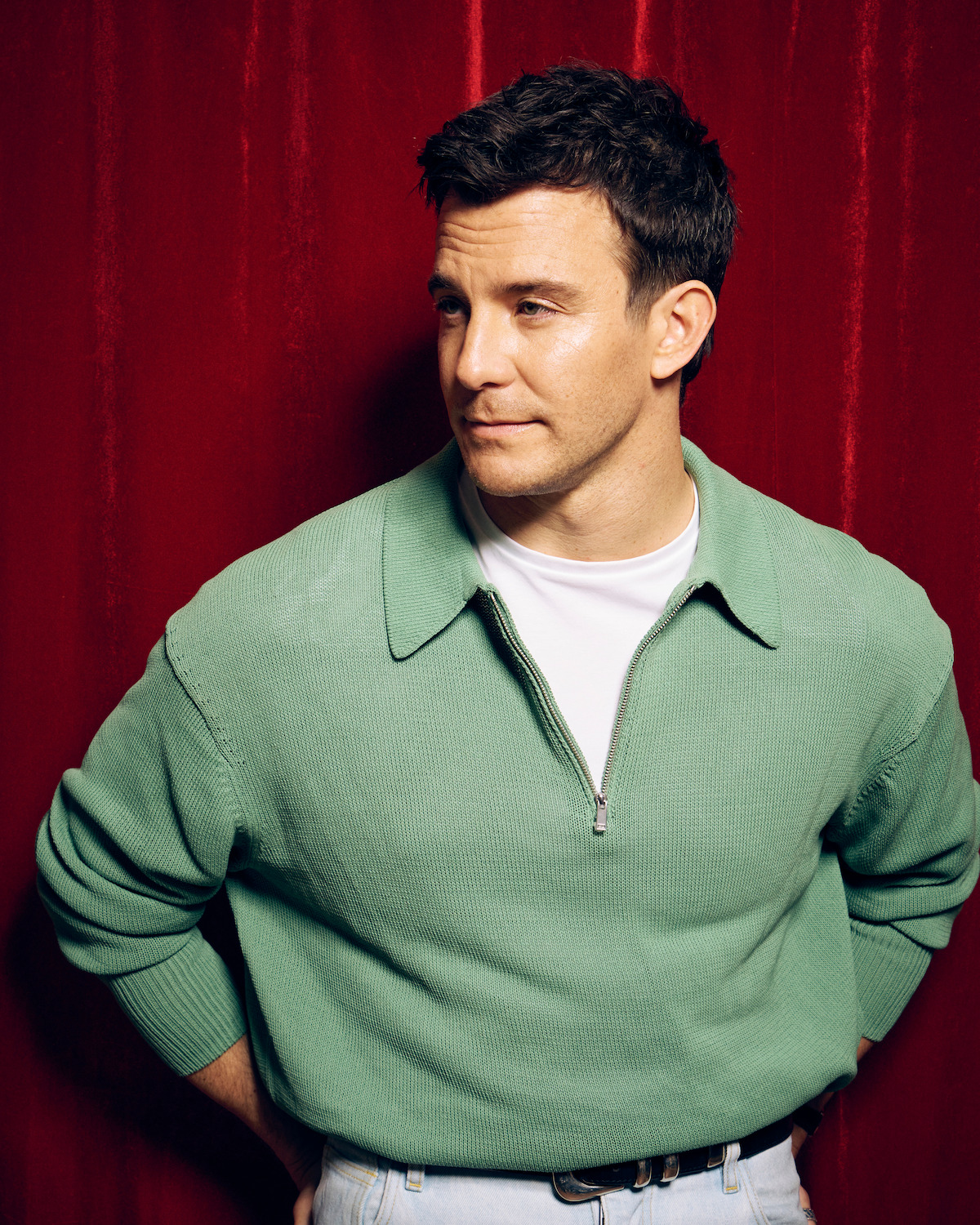Luke Thompson against a red photo booth backdrop