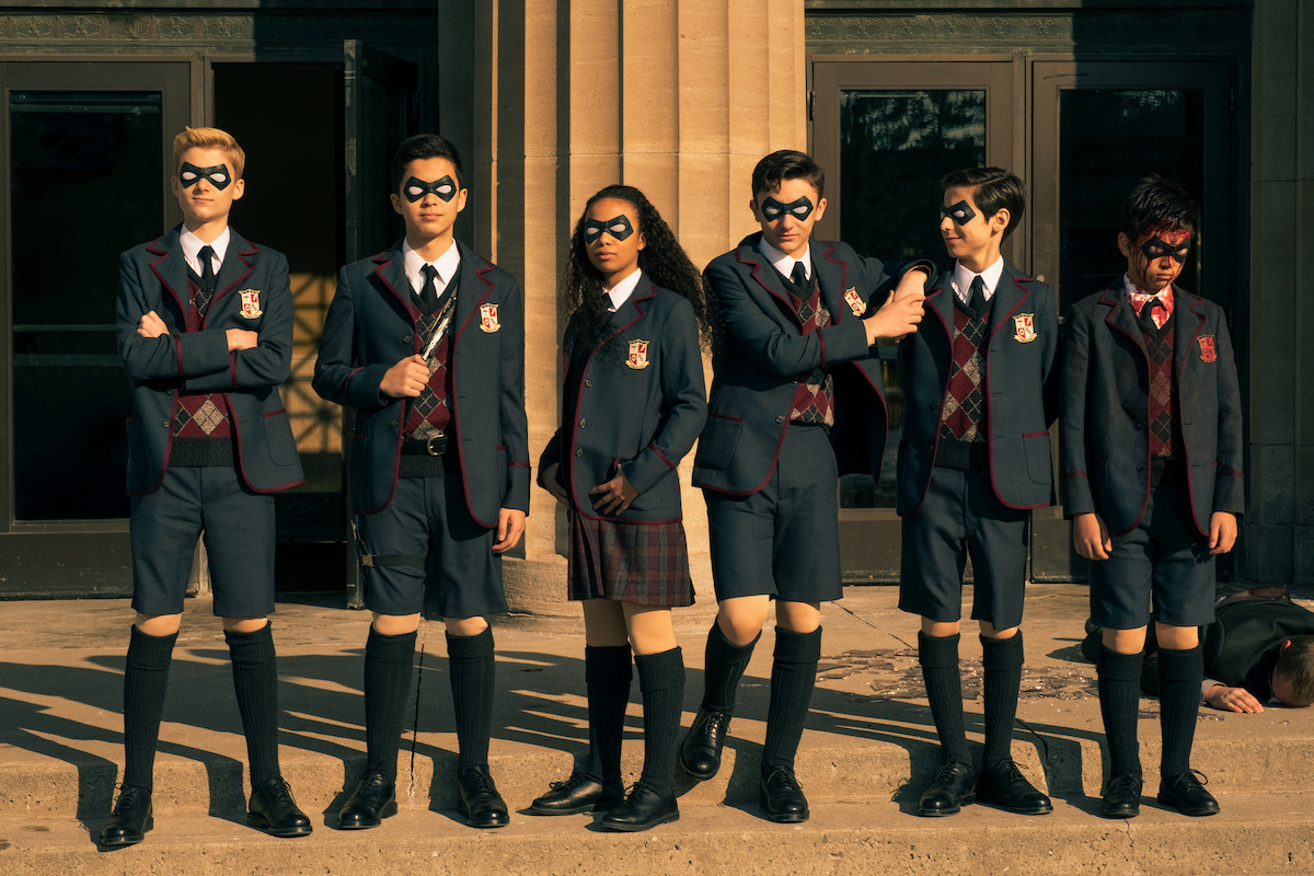  A group of kids in private school uniform, all wearing black and white eye masks.