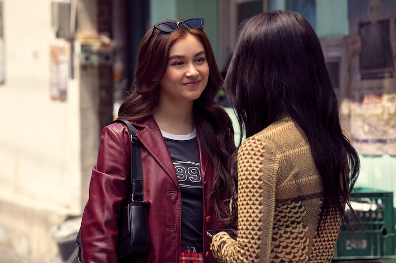 Anna Cathcart as Kitty Song Covey and Gia Kim as Yuri Han face each other on a street outdoors in Season 2 of 'XO, Kitty'