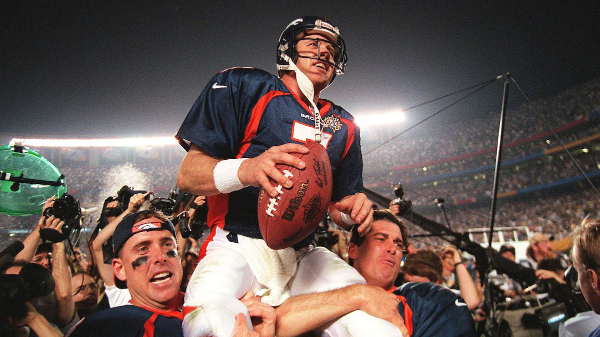 John Elway being carried by his teammates.