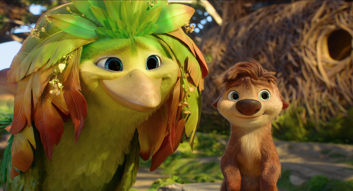Colorful animated bird with leafy feathers and a smiling furry animal stand together outside in a bright, nature-filled environment with trees and a large round nest in the background.