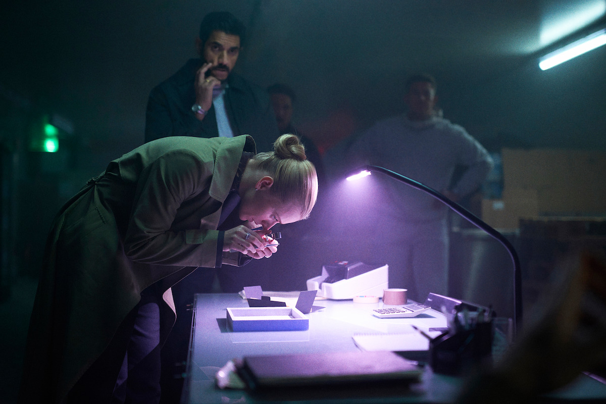 Soheil Bavi as Yasin and Clara Dessau as Tea Lind examine diamonds in ‘The Asset.’