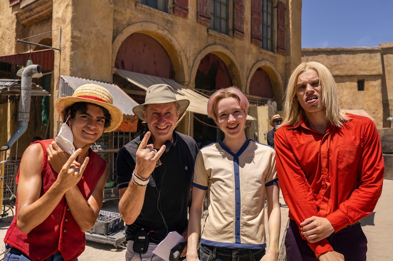 Iñaki Godoy as Monkey D. Luffy, director Marc Jobst, Morgan Davies as Koby, and Aidan Scott as Helmeppo pose together on set in season 1 of 'One Piece.'